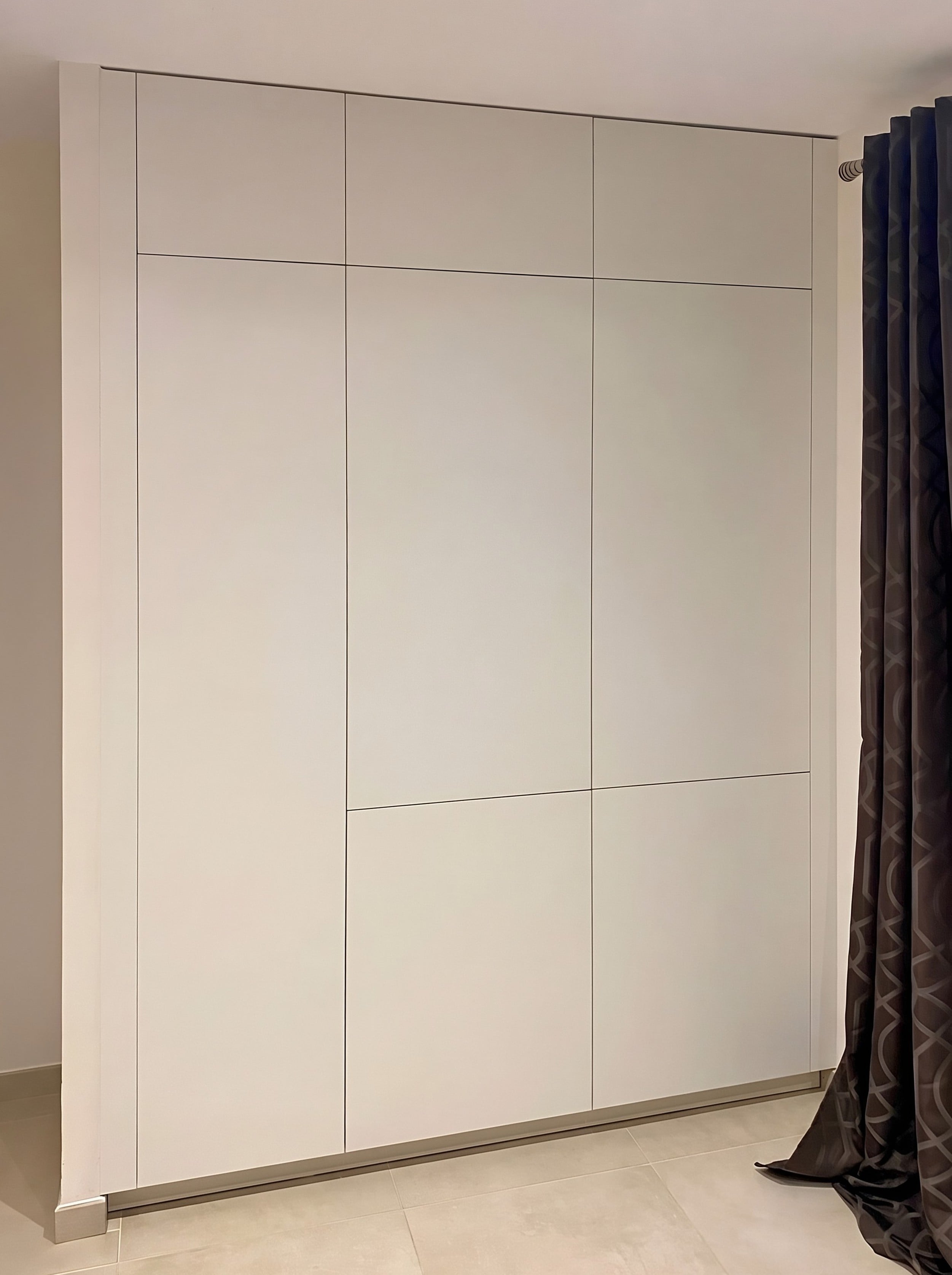 Placard blanc toute hauteur sans poignées, aménagé du sol au plafond