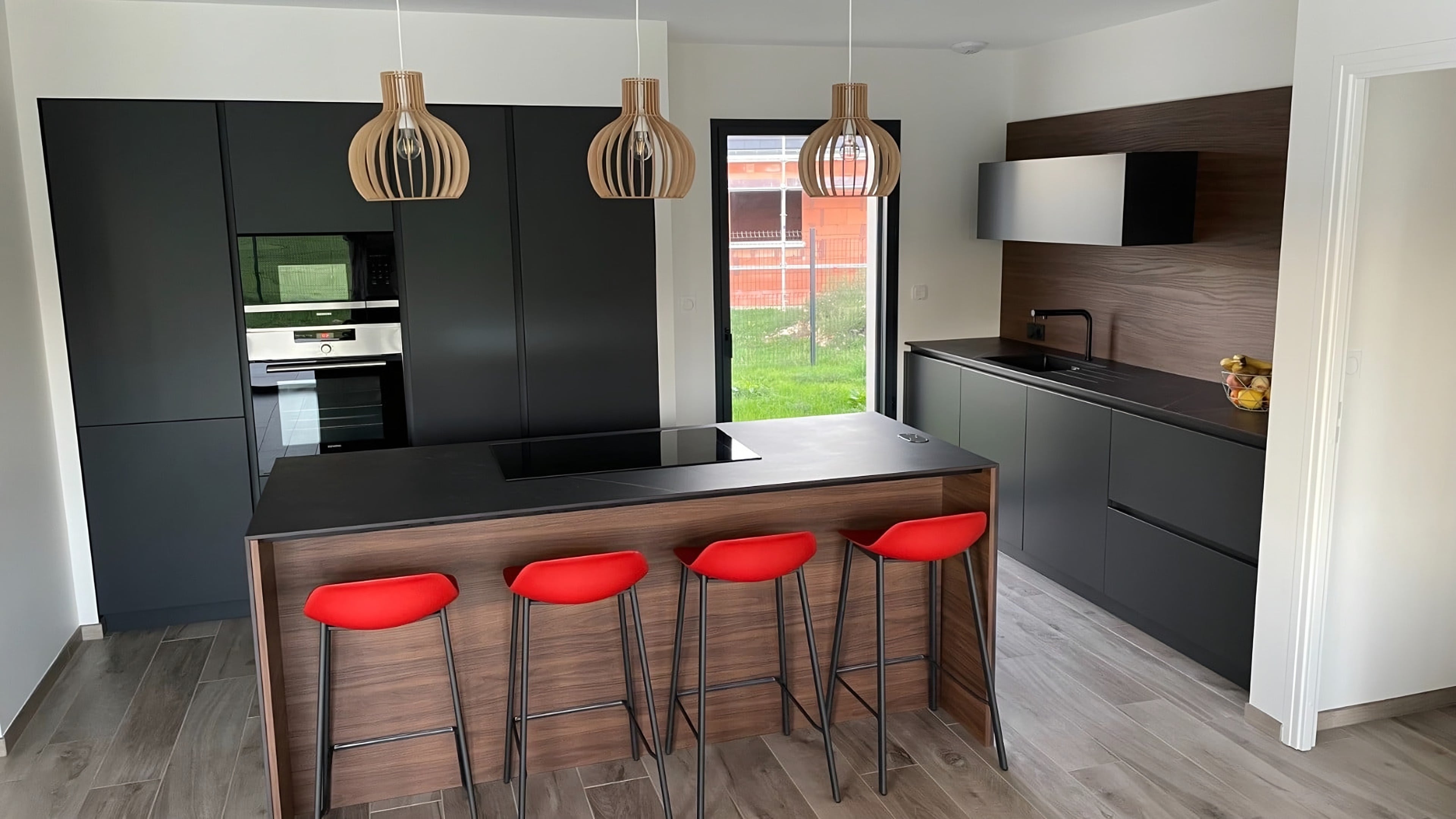 Plan en céramique Dekton Kelya sur l’îlot, meubles bas sans poignées et crédence en bois