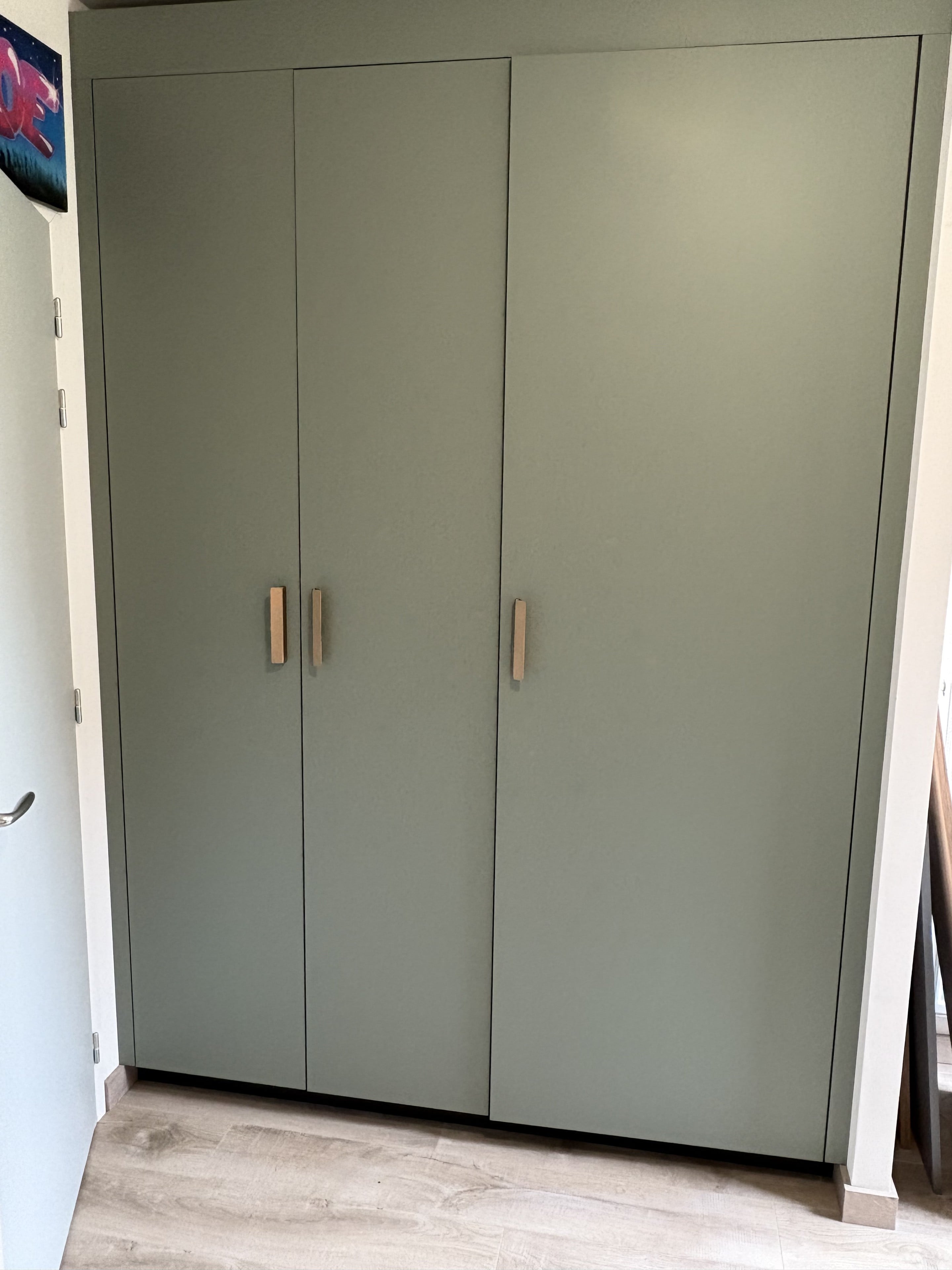 Dressing toute hauteur vert sauge aux poignées en bois clair