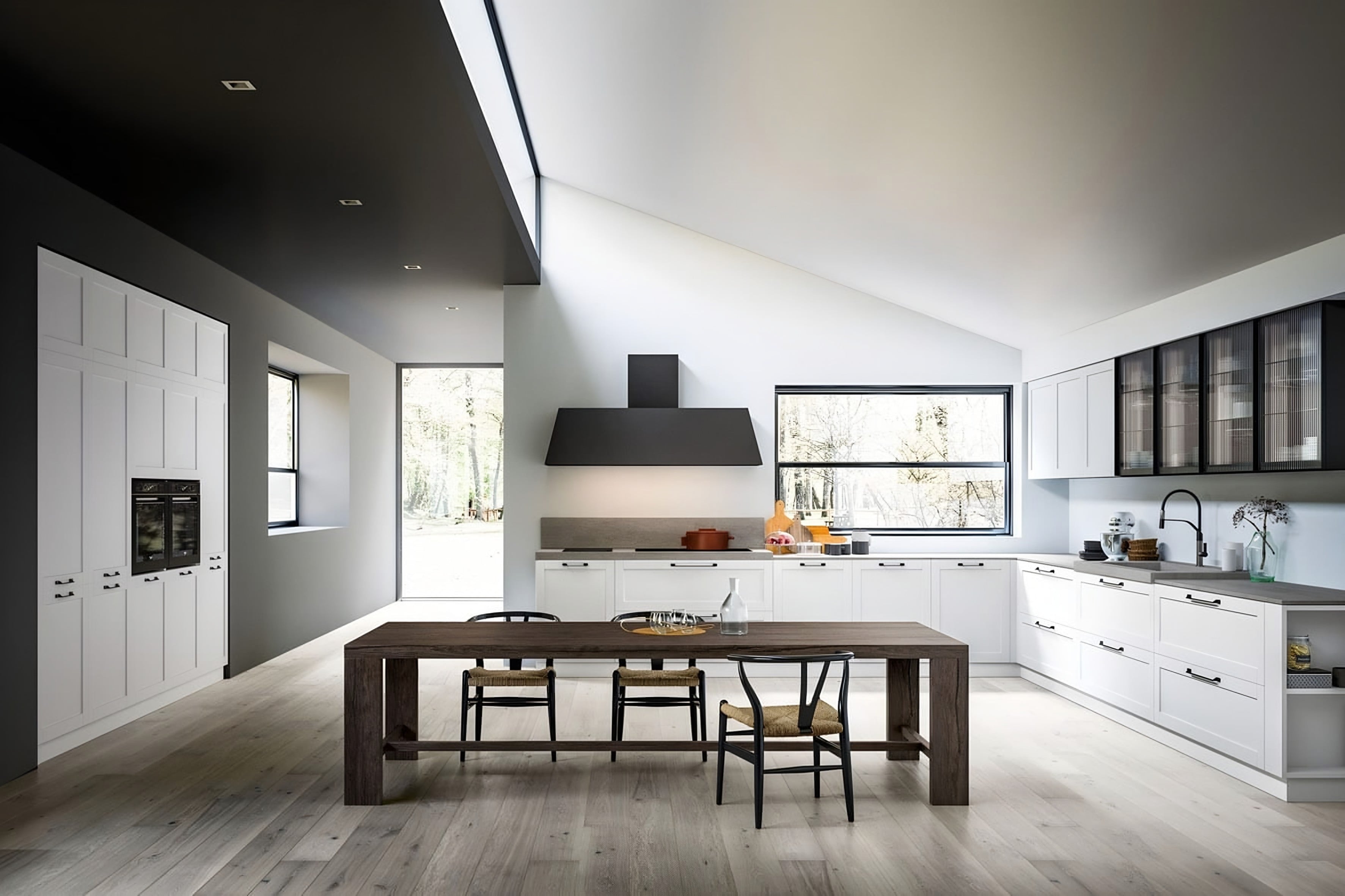 Cuisine Armony Etro : façades blanches à cadre, meubles hauts vitrés noirs et grande table en bois